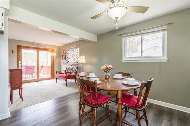 dining room with a healthy amount of sunlight, baseboards, a ceiling fan, and dark wood-style flooring