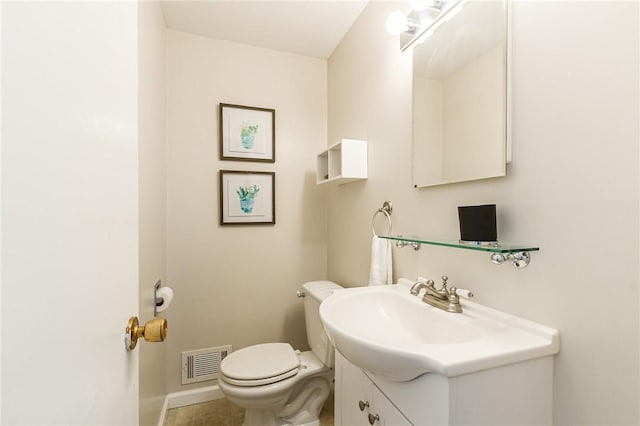 half bath with baseboards, vanity, toilet, and visible vents