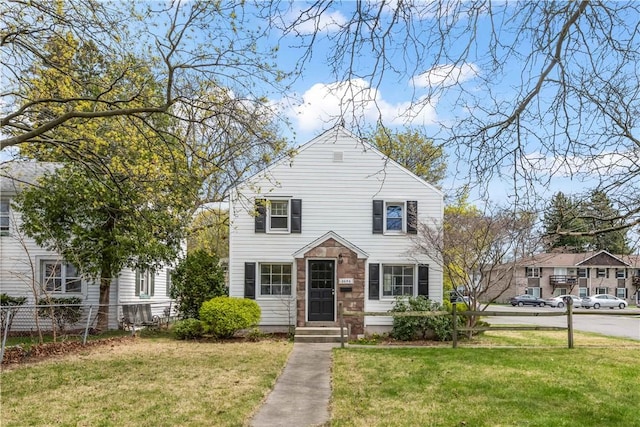 view of front of house with a front lawn and fence