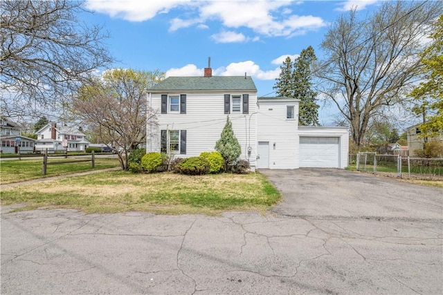 view of front facade featuring fence, an attached garage, a front lawn, aphalt driveway, and a chimney