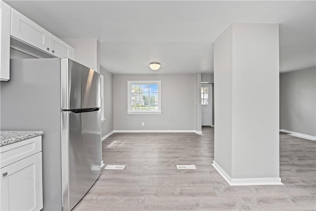 kitchen with freestanding refrigerator, baseboards, and light wood-type flooring
