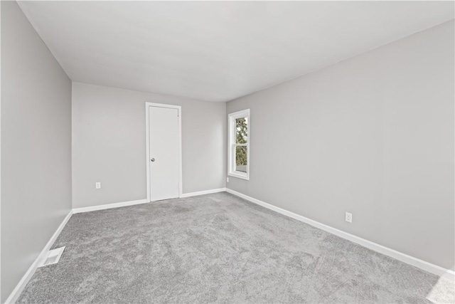unfurnished room featuring carpet flooring, baseboards, and visible vents