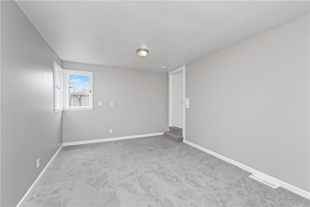 spare room featuring carpet floors, baseboards, and visible vents