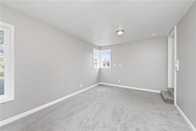 carpeted spare room with baseboards