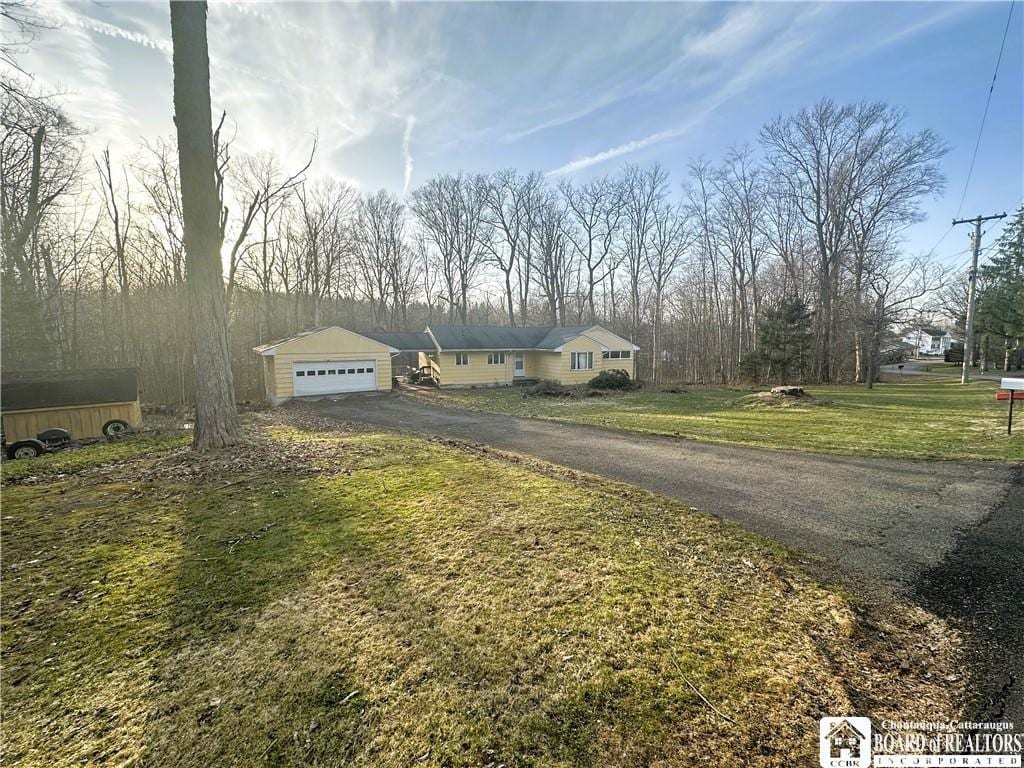 view of front of property with a garage, driveway, and a front lawn