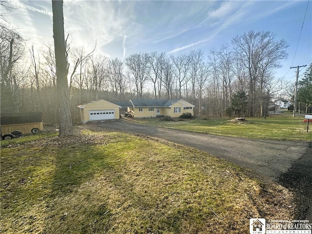 view of front of property with a garage, driveway, and a front lawn