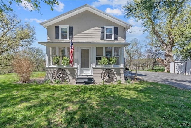 view of front facade with entry steps, an outdoor structure, and a front yard