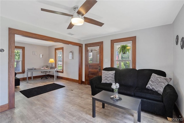living area with visible vents, baseboards, a healthy amount of sunlight, and light wood-type flooring