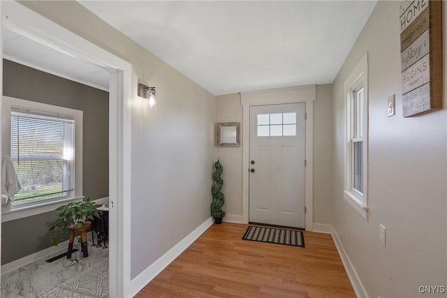 entryway with baseboards and light wood-style flooring