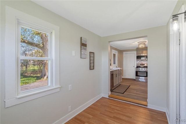 hallway featuring baseboards and light wood-style flooring