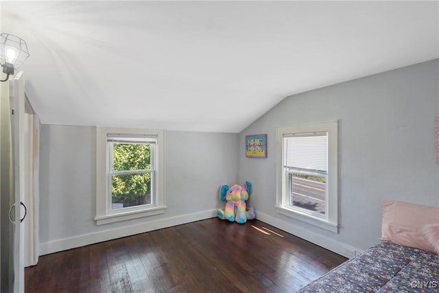 unfurnished bedroom with wood-type flooring, baseboards, and vaulted ceiling