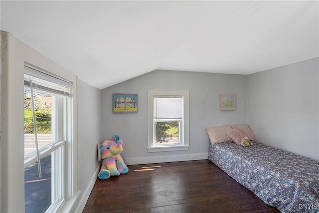 bedroom with baseboards, lofted ceiling, and hardwood / wood-style floors