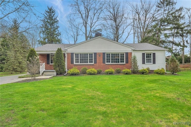 ranch-style home featuring brick siding, a chimney, and a front lawn