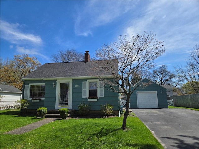 view of front of home featuring a garage, a front lawn, fence, a chimney, and driveway
