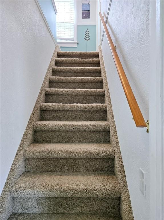staircase featuring a textured wall