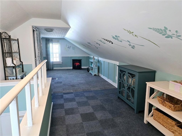 bonus room with vaulted ceiling and dark colored carpet