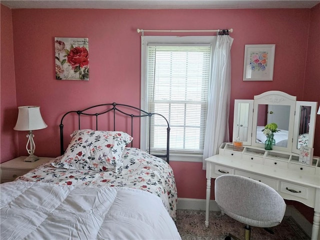 bedroom featuring baseboards and multiple windows