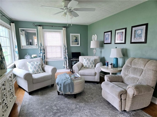 living area featuring a textured ceiling, ceiling fan, and wood finished floors