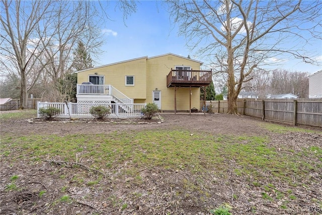 rear view of property featuring a deck and a fenced backyard