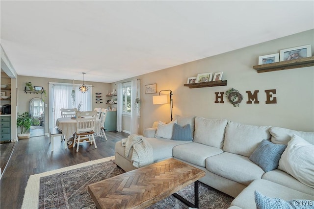 living area with baseboards and wood finished floors