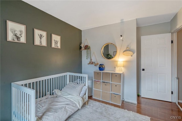 bedroom featuring baseboards and wood finished floors