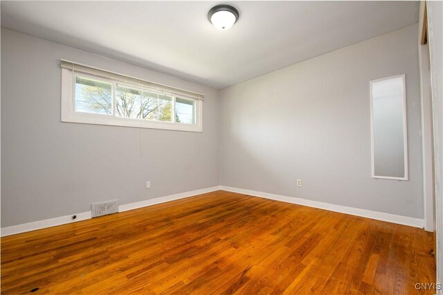 216 Pine Grove St, Syracuse, NY 13210 - spare room featuring baseboards, wood finished floors, and visible vents