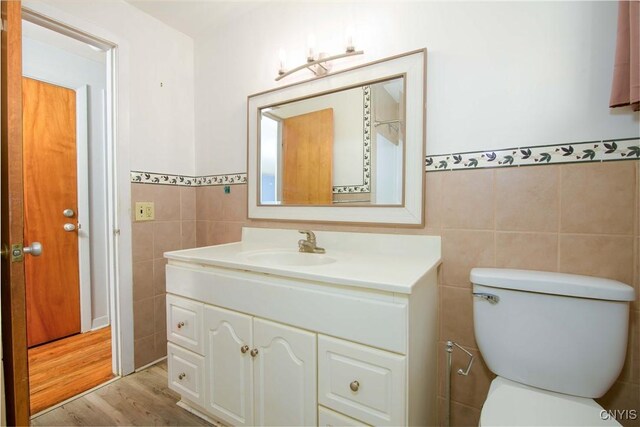 216 Pine Grove St, Syracuse, NY 13210 - bathroom featuring tile walls, wood finished floors, a wainscoted wall, vanity, and toilet
