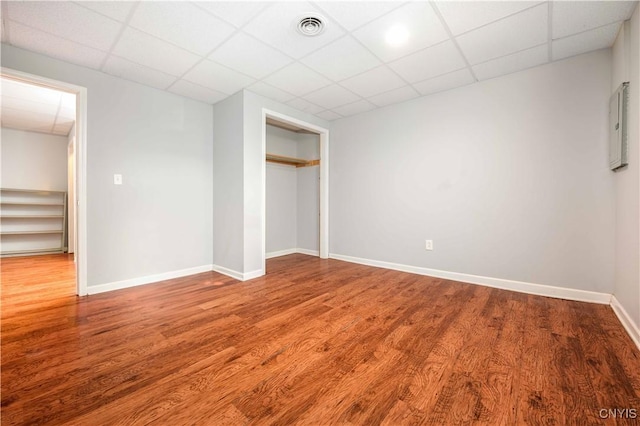 216 Pine Grove St, Syracuse, NY 13210 - unfurnished bedroom featuring visible vents, baseboards, a paneled ceiling, and wood finished floors