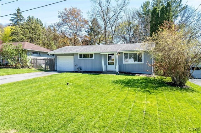 216 Pine Grove St, Syracuse, NY 13210 - ranch-style house with concrete driveway, fence, a front lawn, and a garage