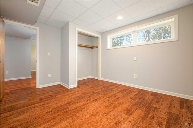 216 Pine Grove St, Syracuse, NY 13210 - unfurnished bedroom with visible vents, a closet, wood finished floors, baseboards, and a drop ceiling