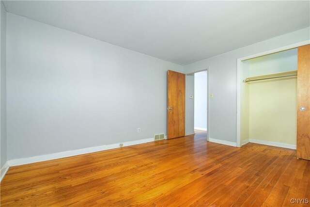 216 Pine Grove St, Syracuse, NY 13210 - unfurnished bedroom with visible vents, baseboards, a closet, and hardwood / wood-style flooring