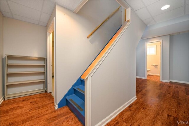 216 Pine Grove St, Syracuse, NY 13210 - staircase featuring wood finished floors, baseboards, and a drop ceiling