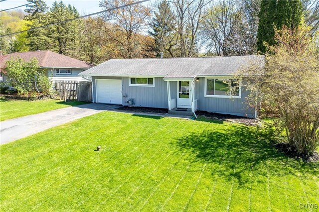 216 Pine Grove St, Syracuse, NY 13210 - ranch-style home featuring a garage, a front lawn, fence, roof with shingles, and driveway