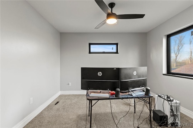 carpeted home office featuring baseboards and ceiling fan