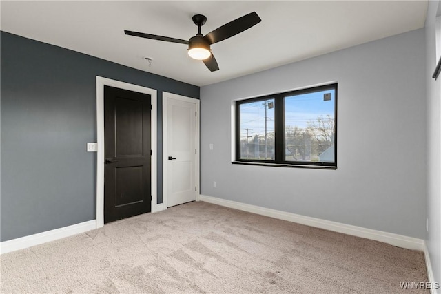 unfurnished bedroom featuring baseboards, carpet, and ceiling fan