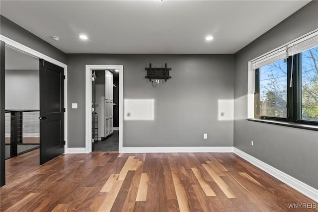 unfurnished room with baseboards, recessed lighting, and wood finished floors