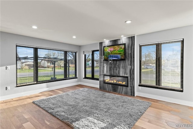 living room with baseboards, recessed lighting, wood finished floors, and a fireplace