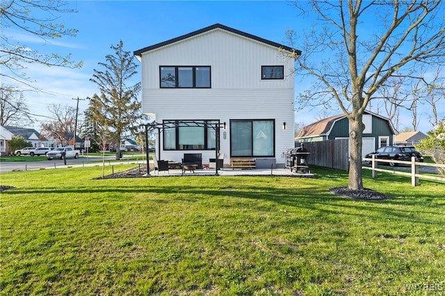 back of house featuring entry steps, fence, a lawn, and a patio area