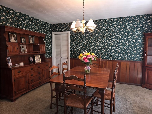 dining room featuring light carpet, wainscoting, wallpapered walls, and a chandelier