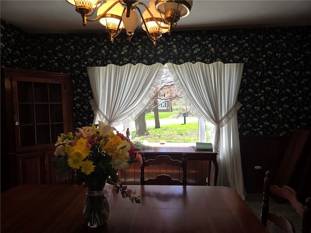 dining room with wallpapered walls and an inviting chandelier