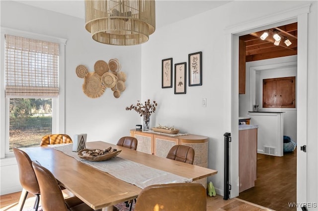 dining space with visible vents and wood finished floors