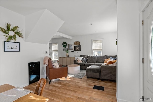 living area with light wood-style floors, wine cooler, and visible vents