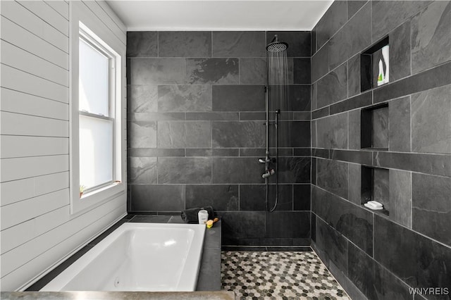 bathroom featuring a garden tub and tiled shower
