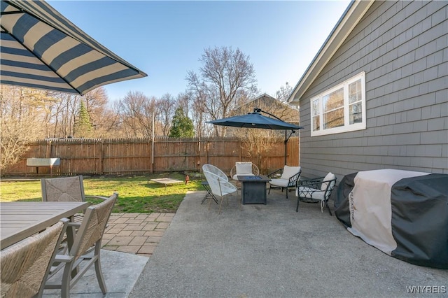 view of patio featuring fence, outdoor dining space, and a grill