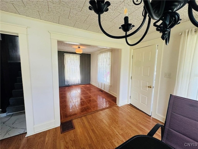 entryway with visible vents, ornamental molding, wood finished floors, baseboards, and stairway