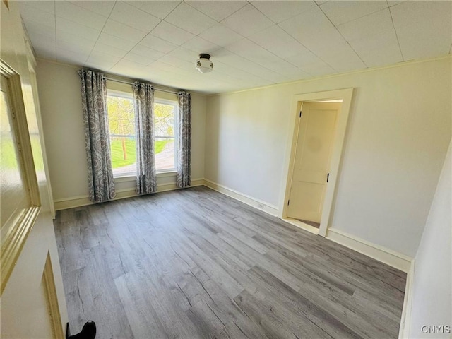 unfurnished room with baseboards and wood finished floors