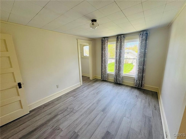 spare room featuring baseboards and wood finished floors