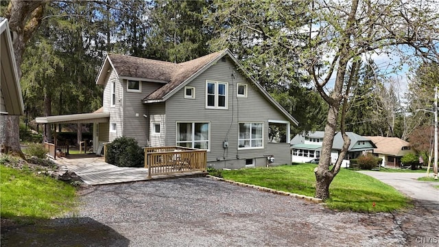 view of front of property with a wooden deck and a front lawn