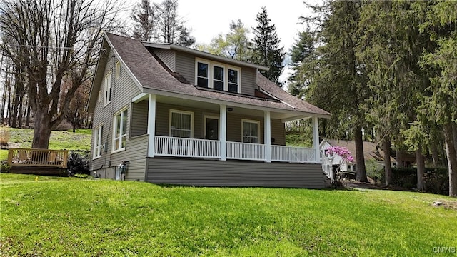 bungalow-style home with a shingled roof, a porch, and a front yard