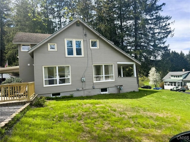 back of house with a lawn and a deck